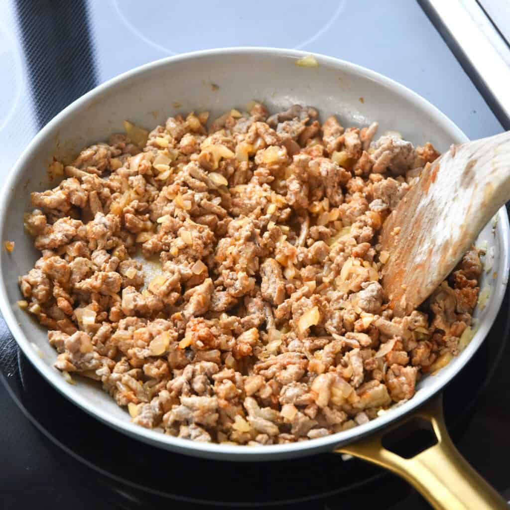 a skillet of ground meat and onions seasoned with tomato paste.