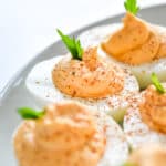 Buffalo deviled eggs with celery green sprig and paprika on top.