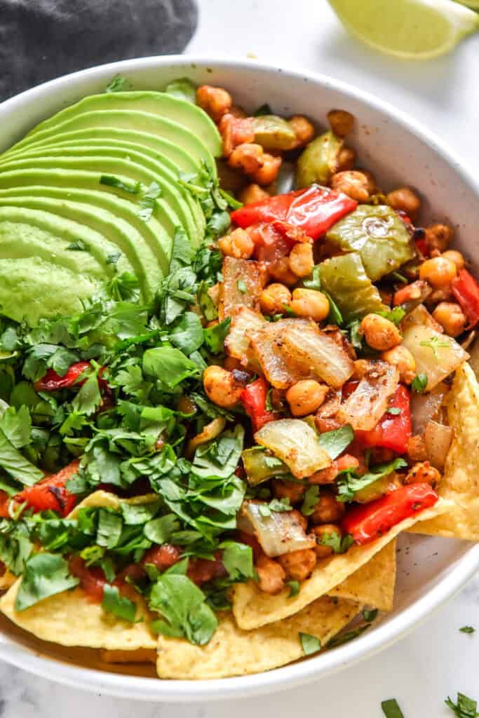 roasted chickpea taco salad bowls with avocado and cilantro on top.