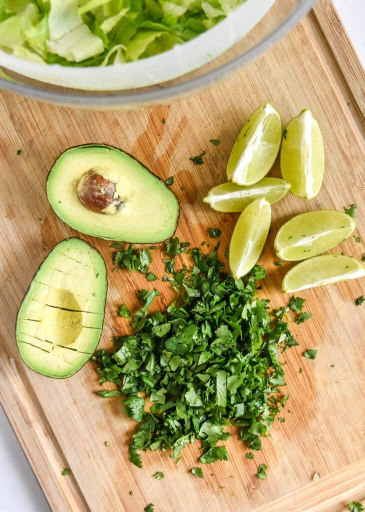 cut avocado and cilantro on a cutting board.