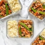 meal prep ground turkey stir fry bowls in glass meal prep containers with rice.