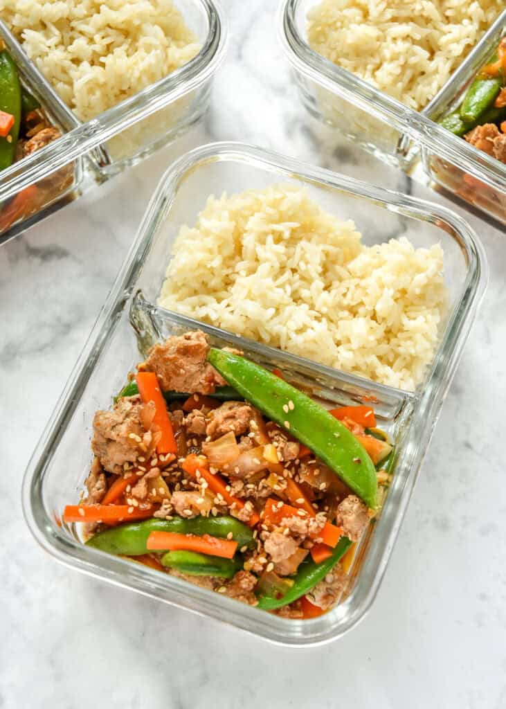 2 compartment glass meal prep container with ground turkey stir fry and rice.