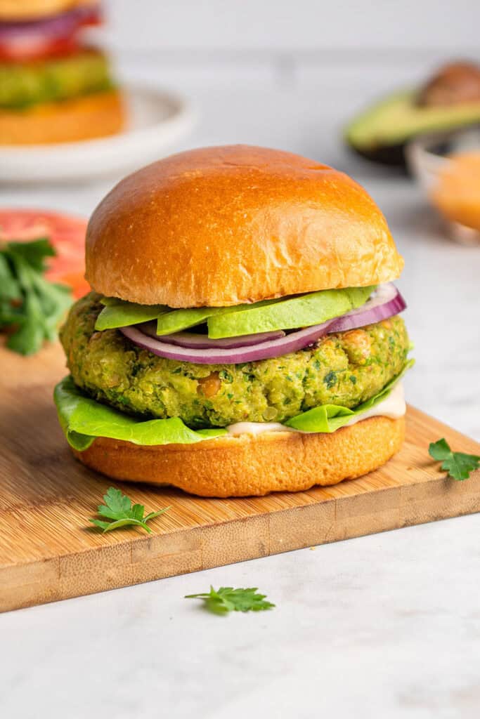 herby chickpea veggie burger on a bun with avocado.