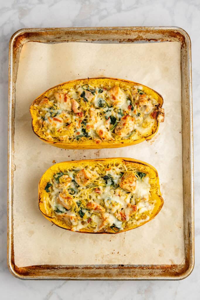 pesto chicken stuffed spaghetti squash on a sheet pan just baked.