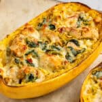 baked pesto chicken stuffed spaghetti squash with golden brown cheese on top.